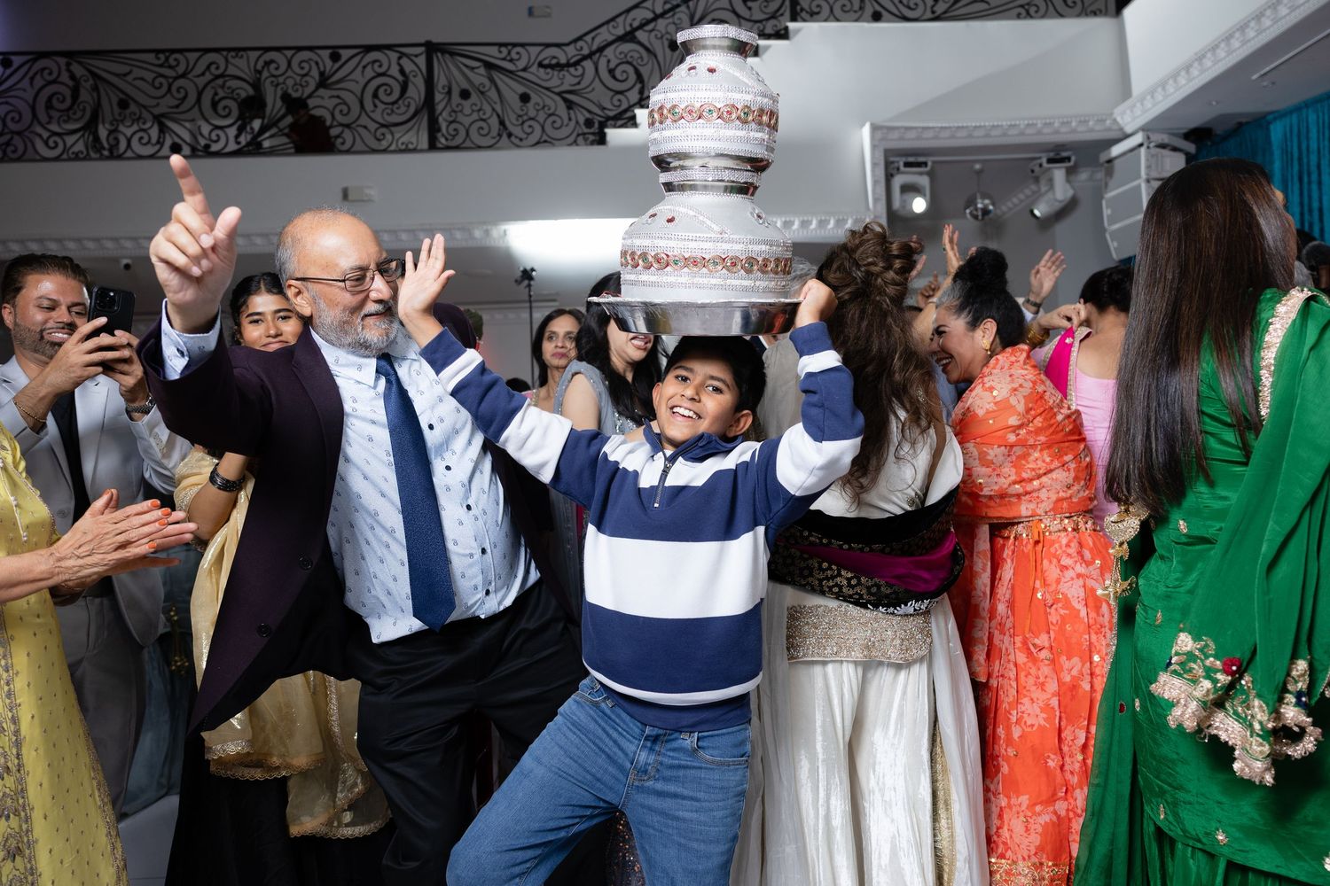 Wedding guests dance and celebrate together on the dance floor at a lively reception party.