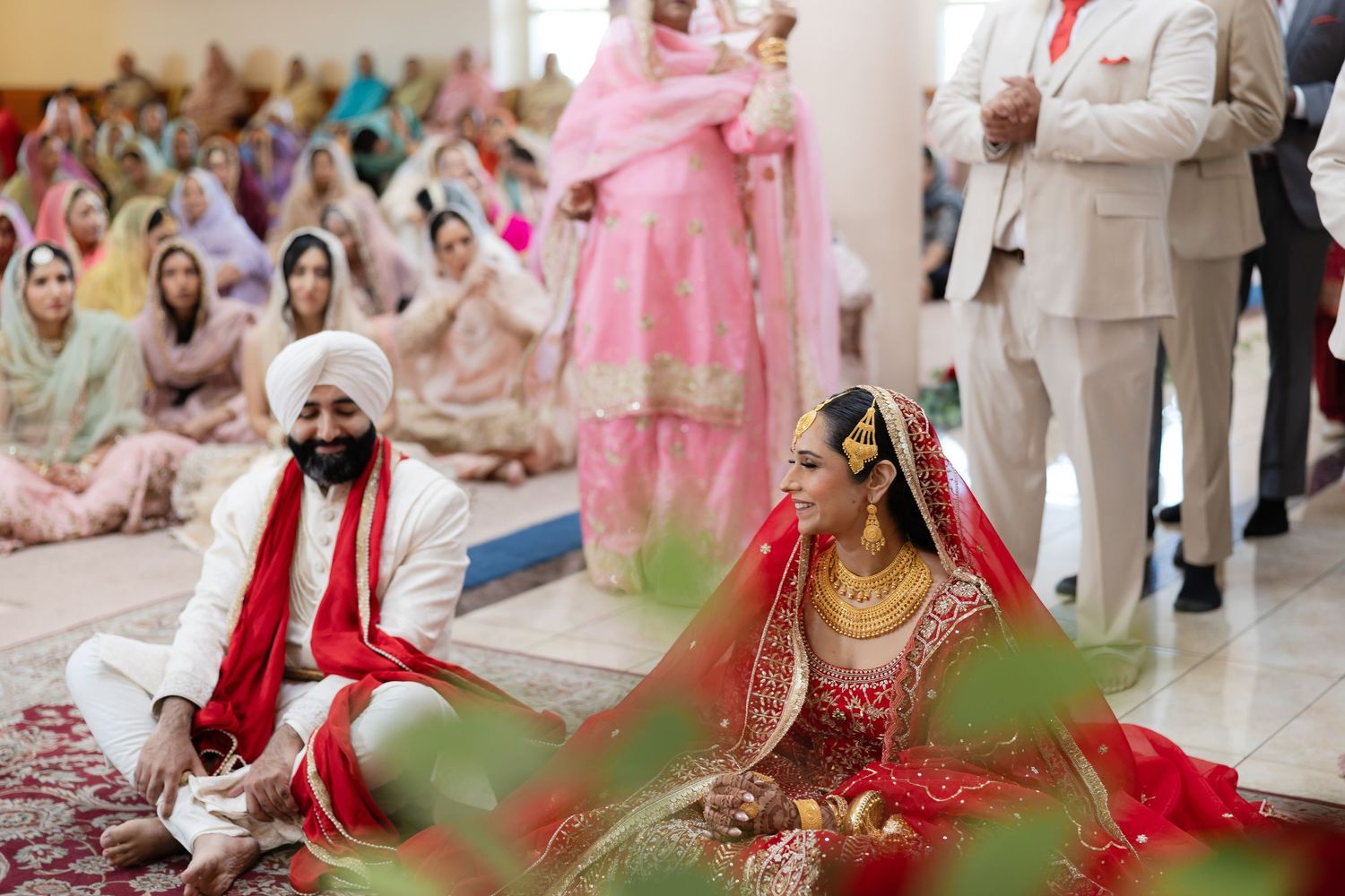 Traditional Indian wedding ceremony with guests in colorful attire seated during cultural rituals.