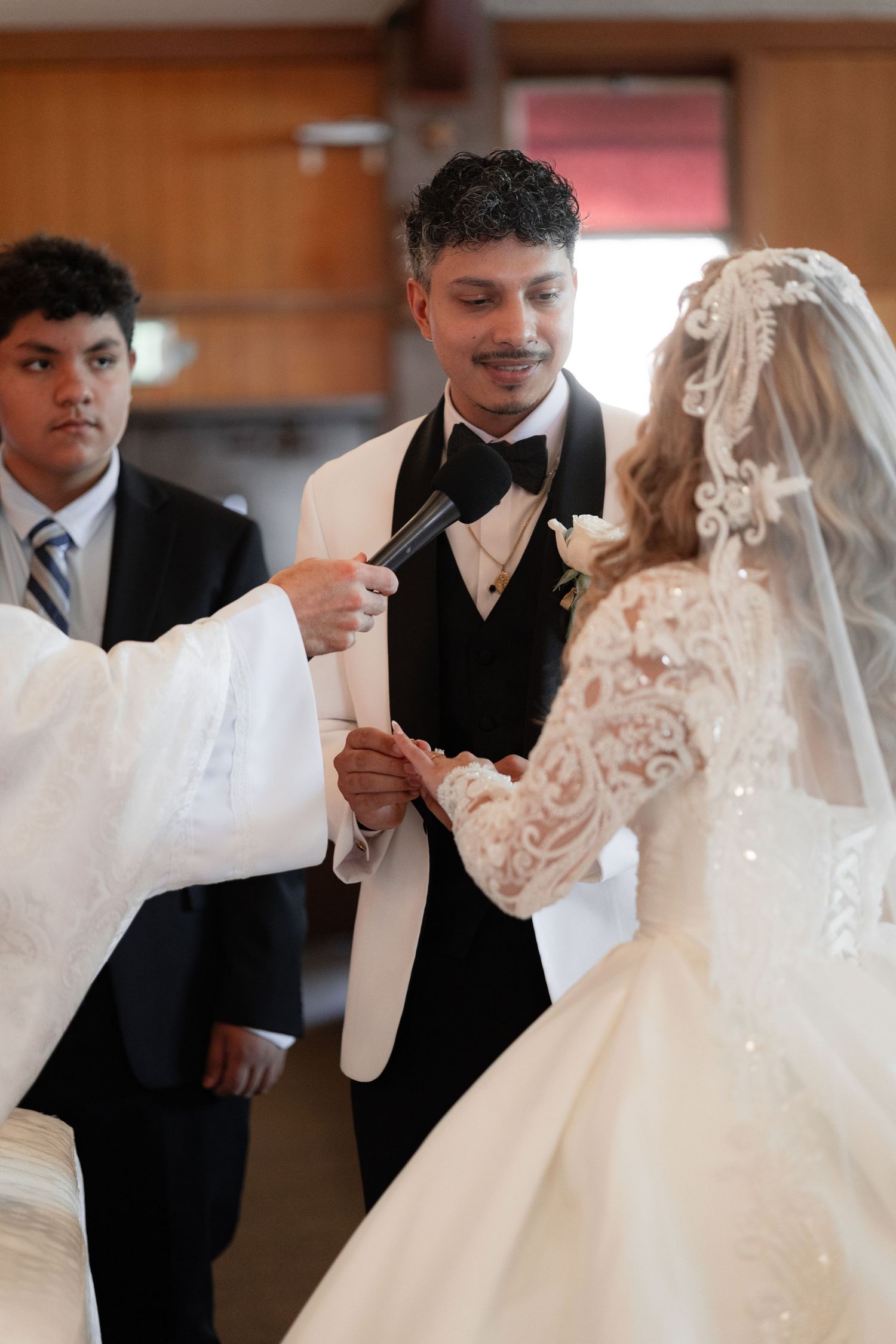 Wedding couple during their ceremony with attendants in formal black and white attire.