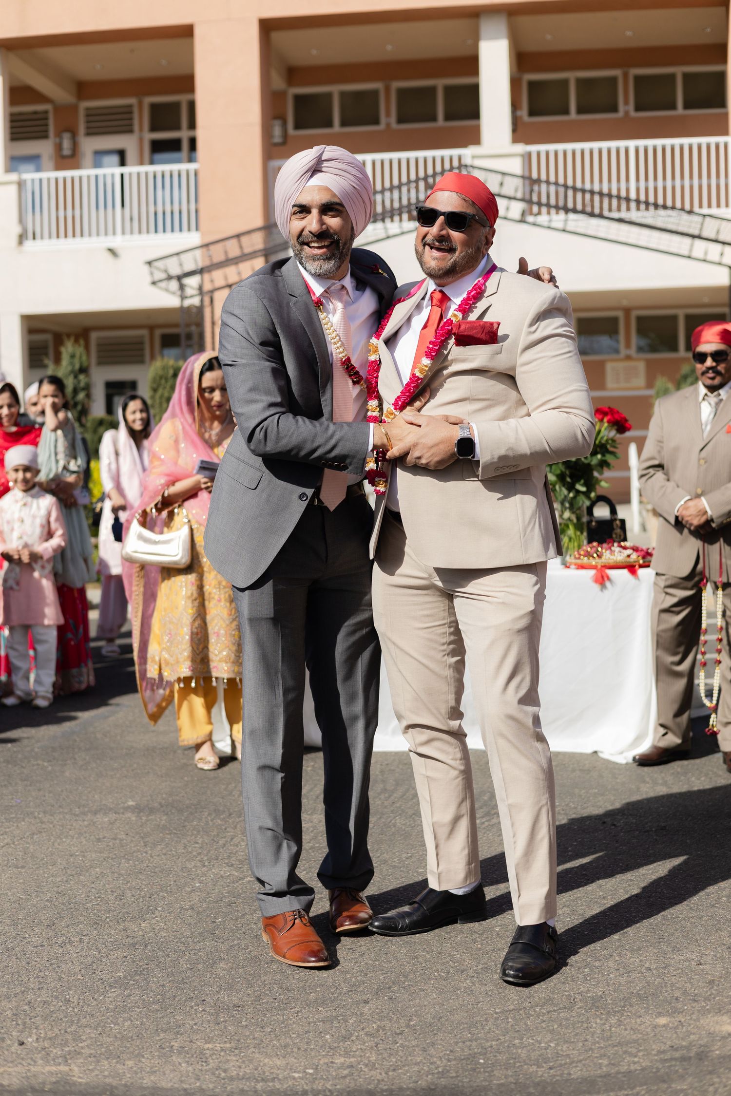 Wedding guests in formal attire celebrating and dancing outdoors at a reception.