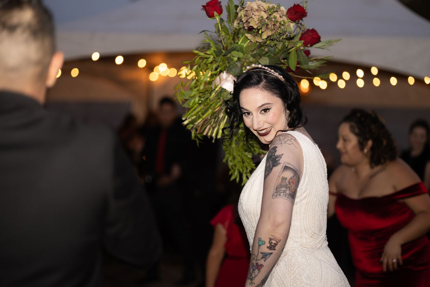 Wedding reception celebration with string lights and floral decorations creating a warm ambiance.