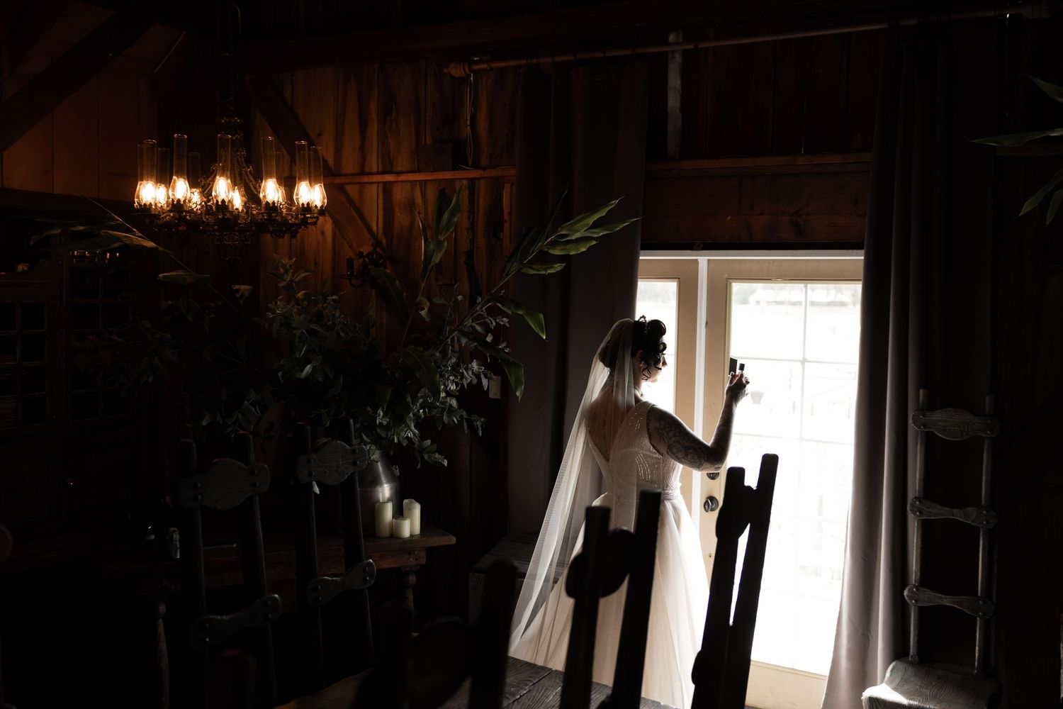 Silhouettes dancing in a rustic barn interior with bright window light creating dramatic contrast.