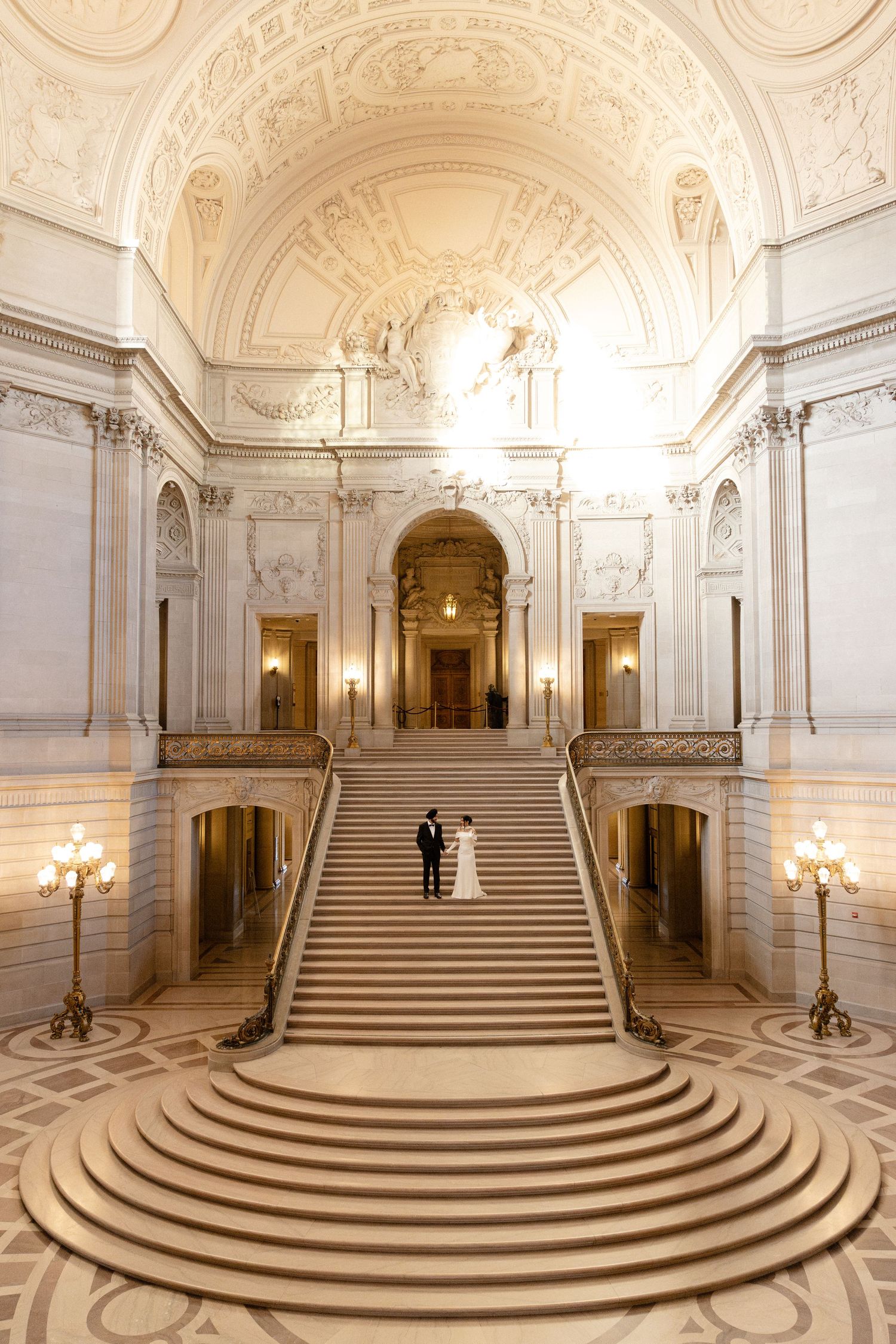 Elegant marble staircase with curved steps in a grand historic building interior.