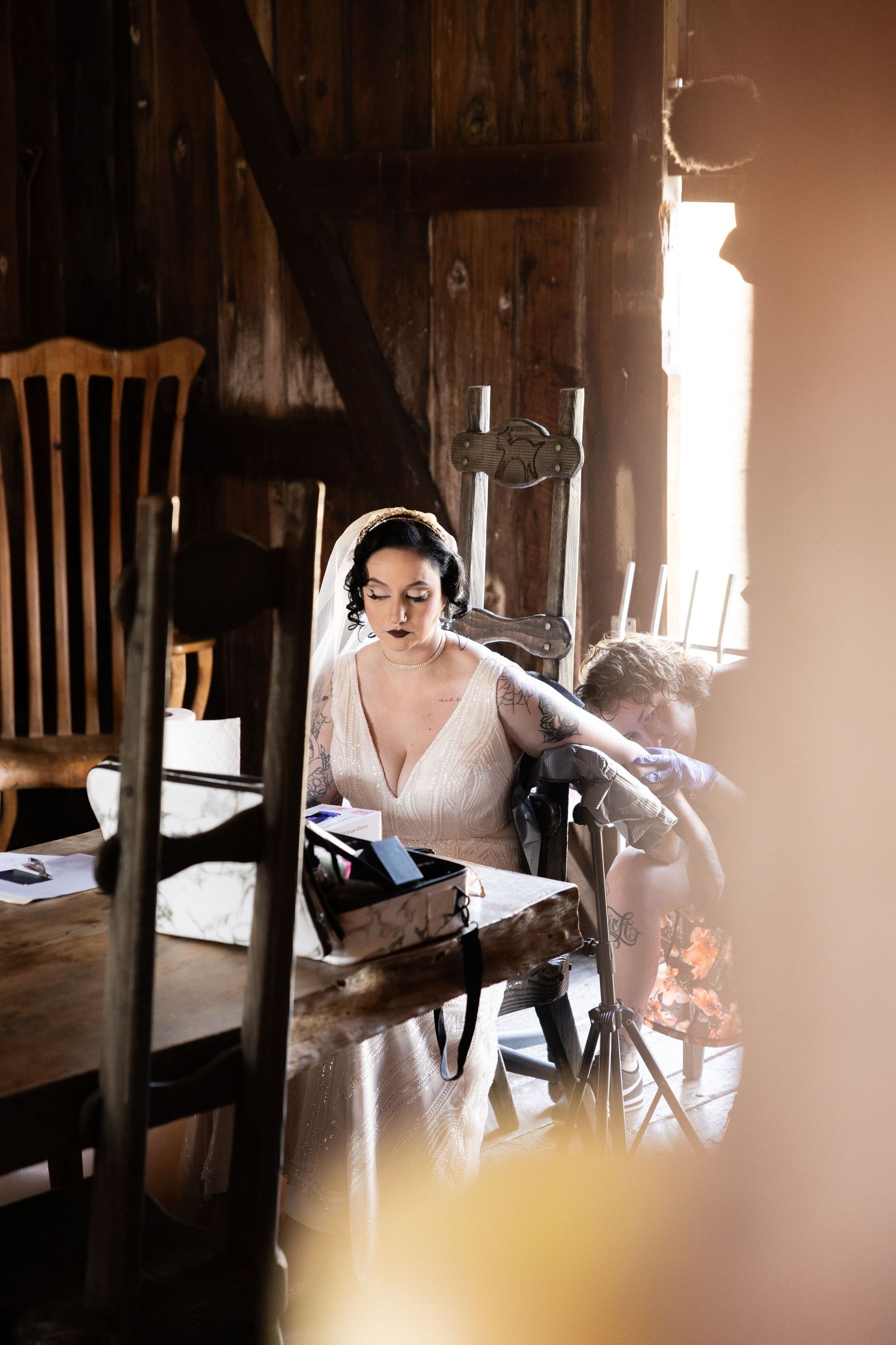 Elegant bridal preparation scene in a rustic wooden interior with natural lighting.