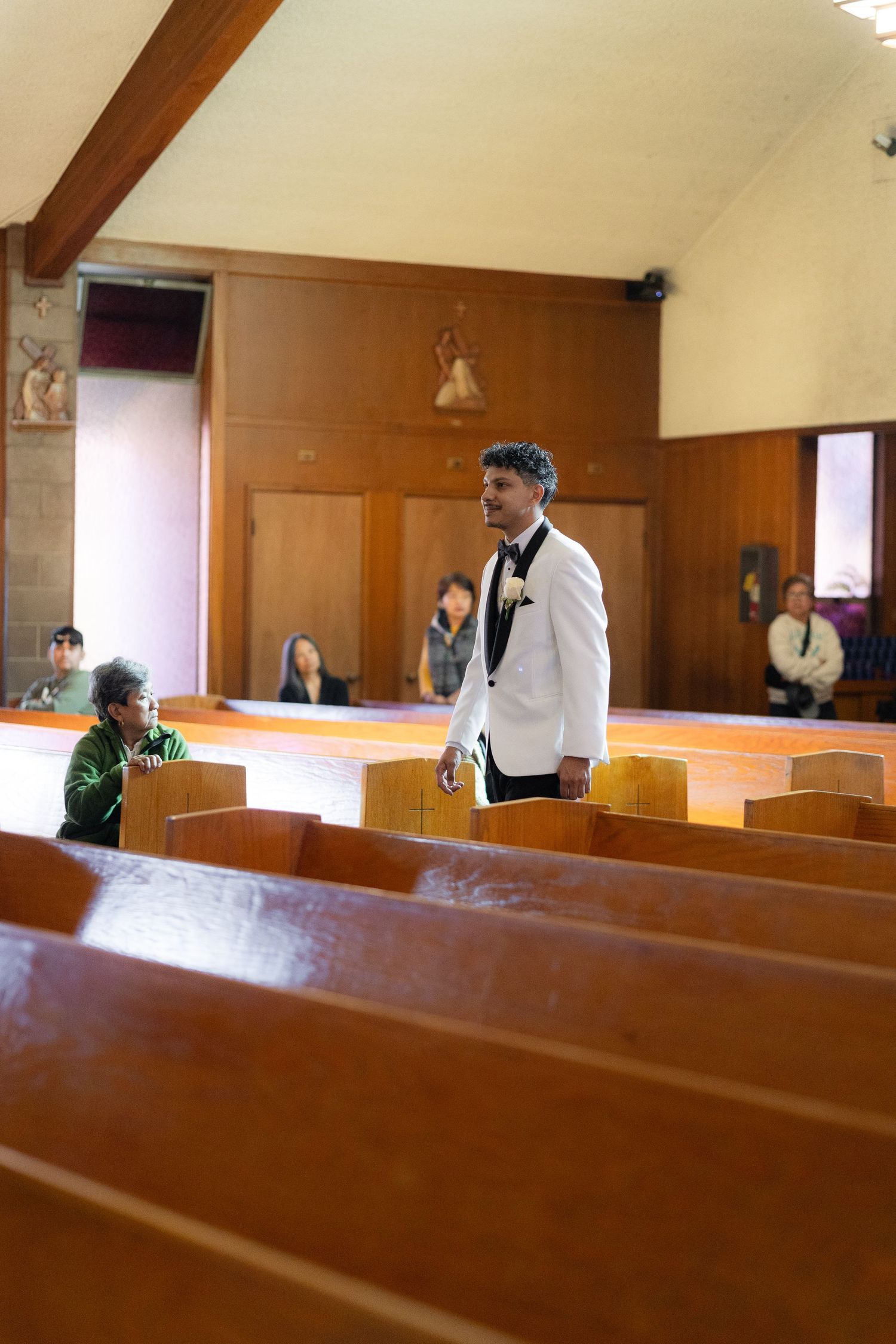 Interior church scene with wooden pews and natural lighting streaming through windows.