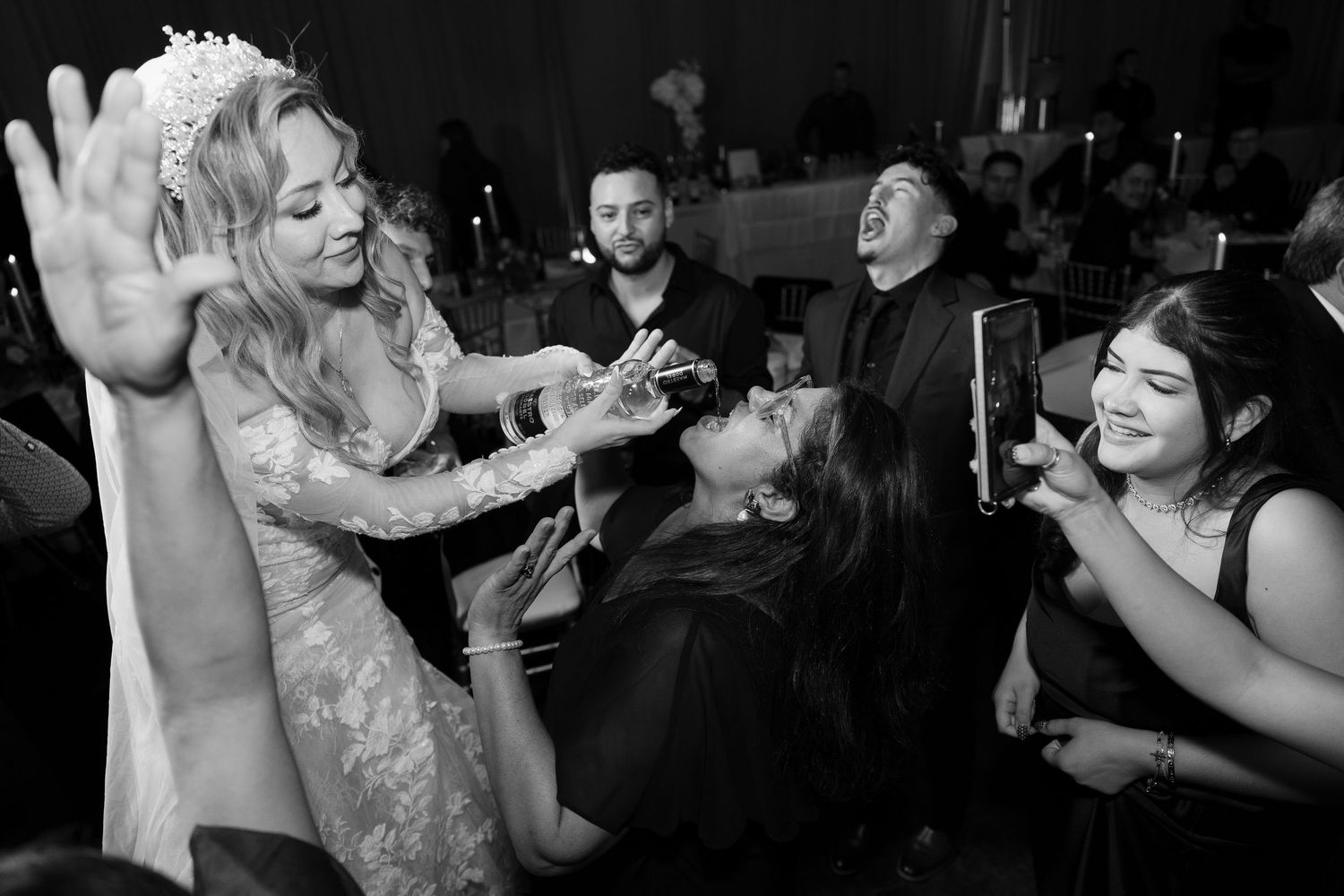 Black and white photo of wedding guests dancing and celebrating at reception.