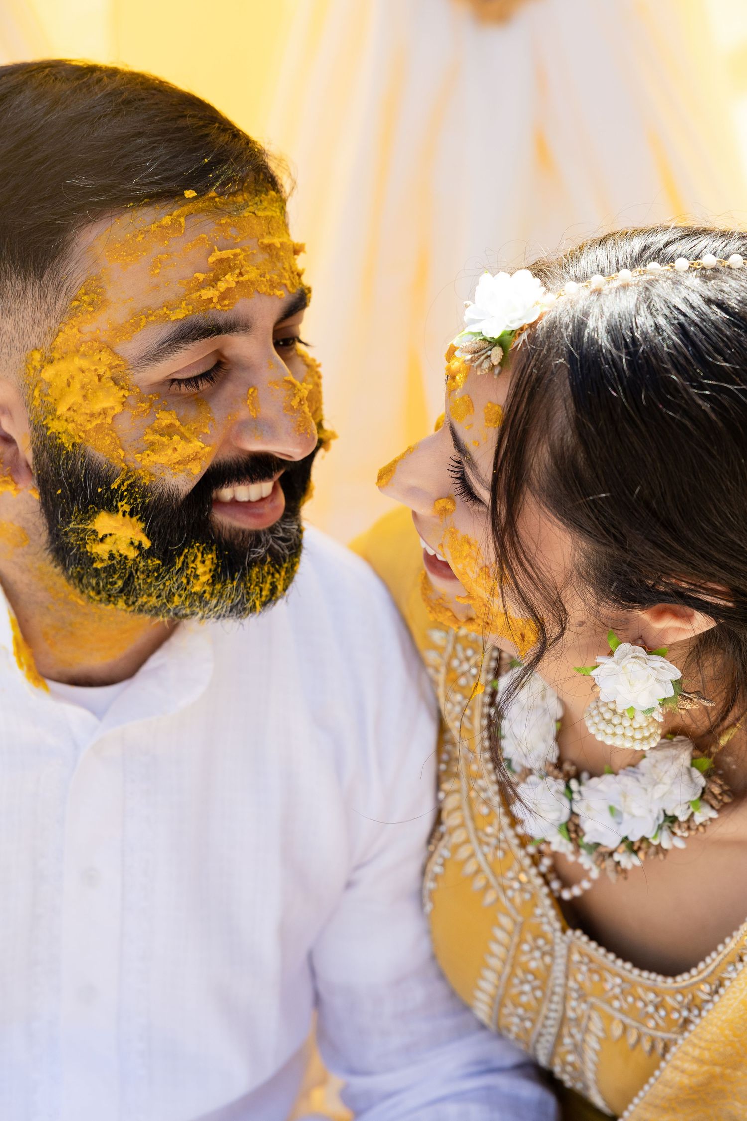 Traditional turmeric ceremony with yellow paste being applied during a wedding ritual.