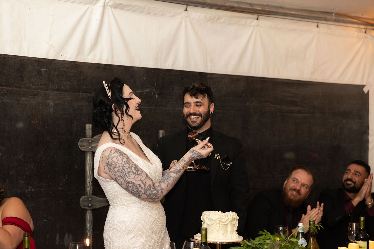 Couple sharing a romantic dance moment in a rustic barn setting with string lights.