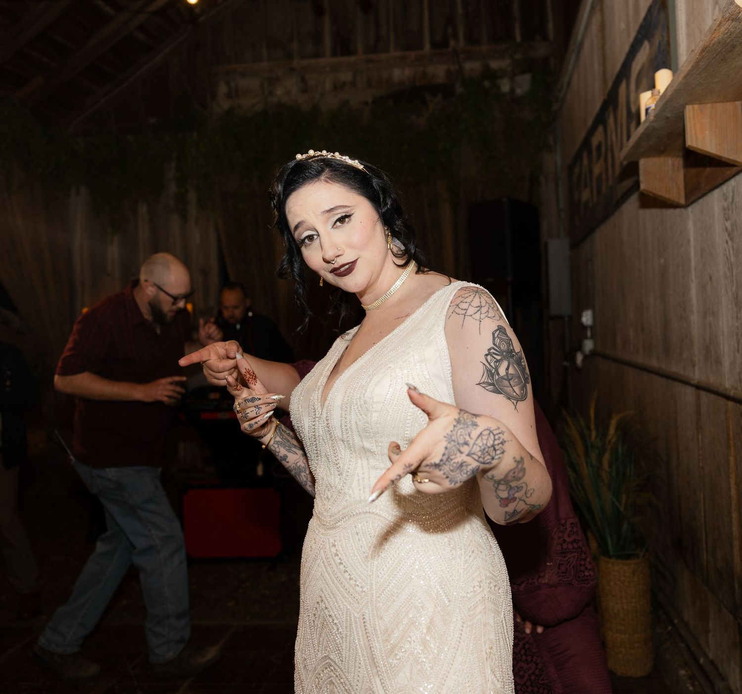 Wedding reception dance party in a charming barn venue with wooden beams and ambient lighting.