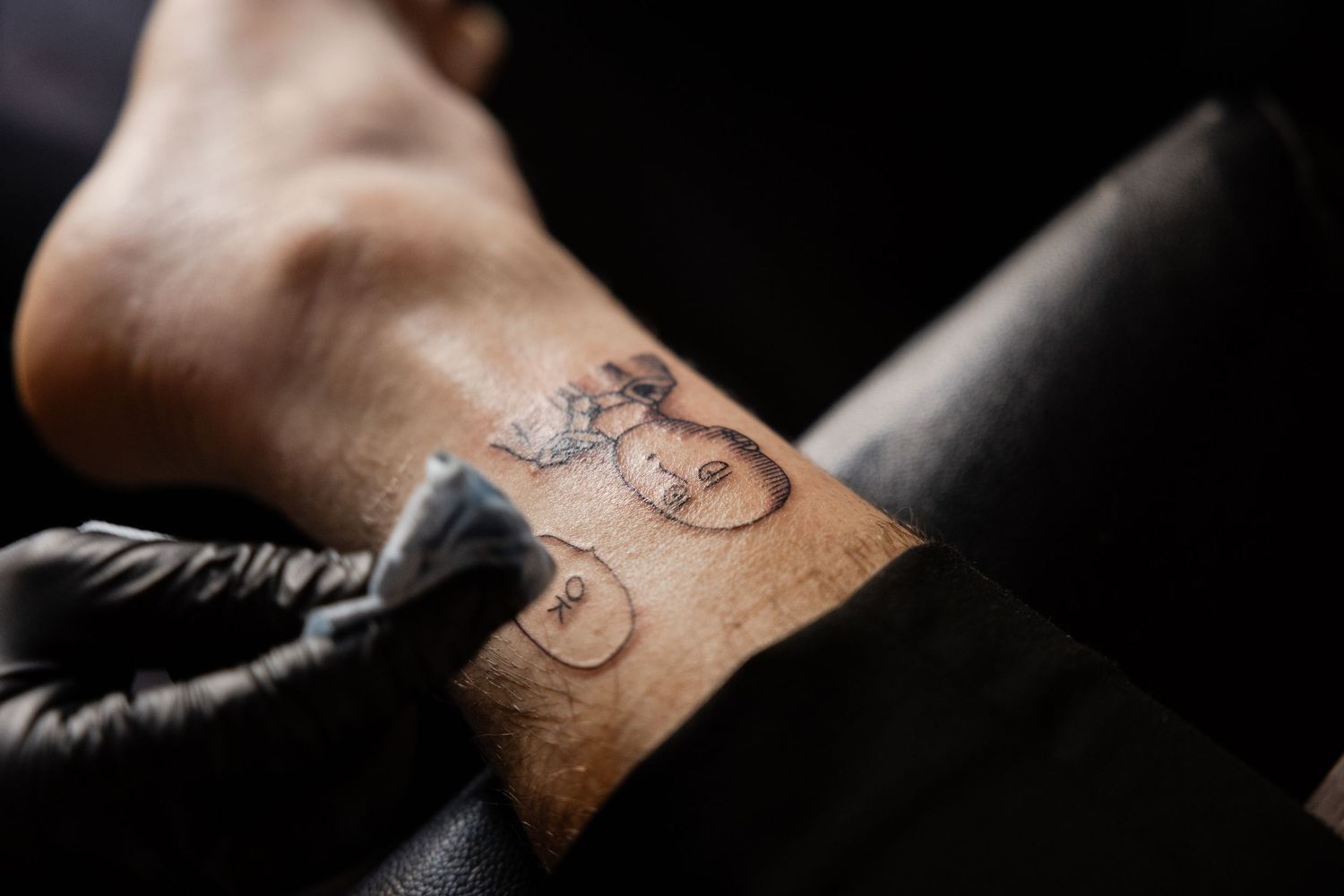 Close-up shot of a small minimalist tattoo being worked on by an artist.