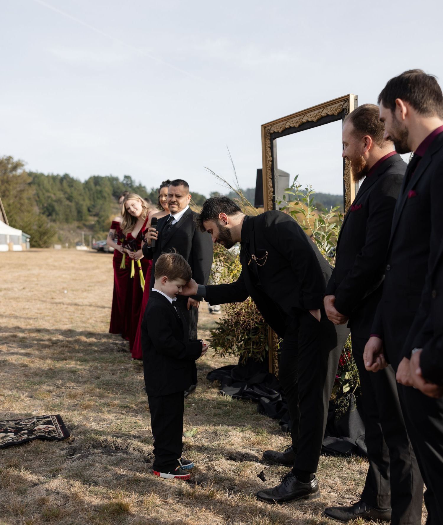 Wedding party members lined up outdoors during ceremony preparations.