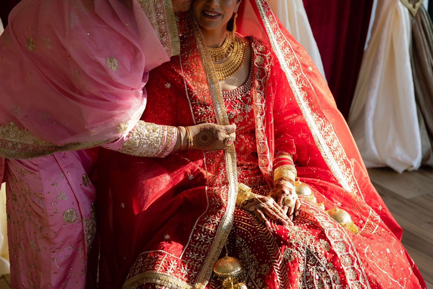Traditional Indian bridal attire with intricate red and gold embroidery details.