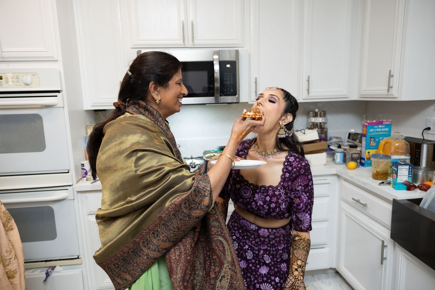 Two people share a tender moment in a kitchen while preparing food together.
