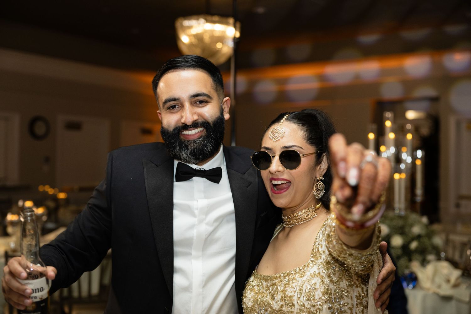 Wedding celebration with guests dancing and enjoying festivities in an elegant indoor venue.
