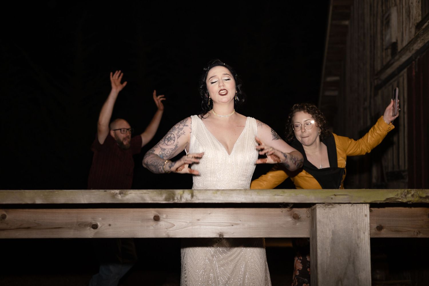 Wedding party celebrates joyfully on the dance floor at a rustic barn venue.