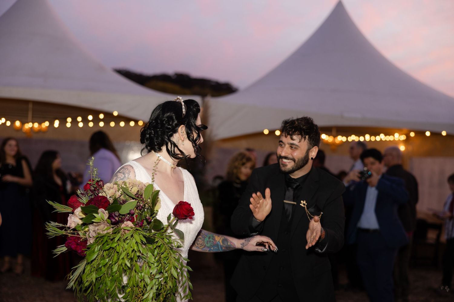 Evening outdoor wedding celebration with festive lighting and decor.