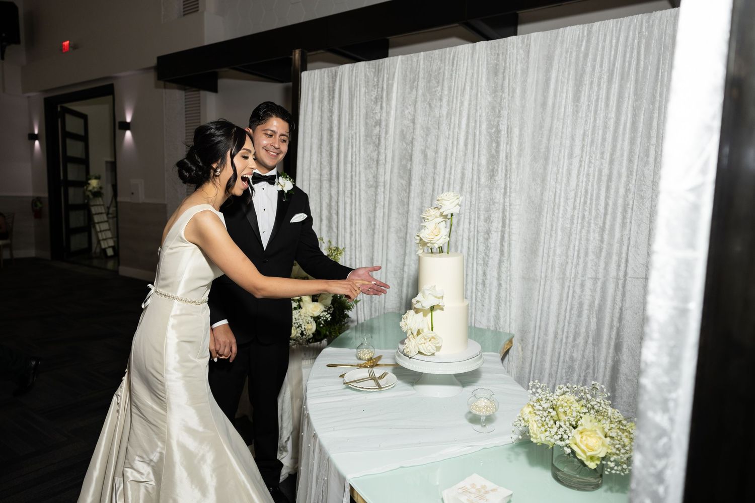 Wedding reception moment with couple sharing cake cutting ceremony.