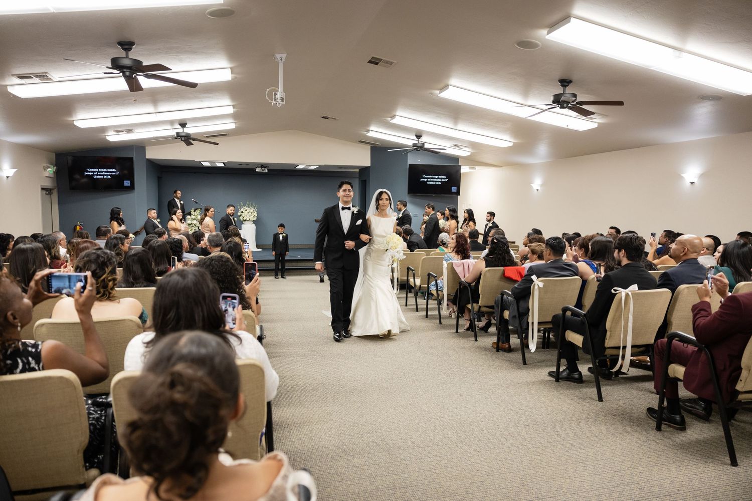 Panoramic view of a wedding venue with guests seated in rows facing the front.
