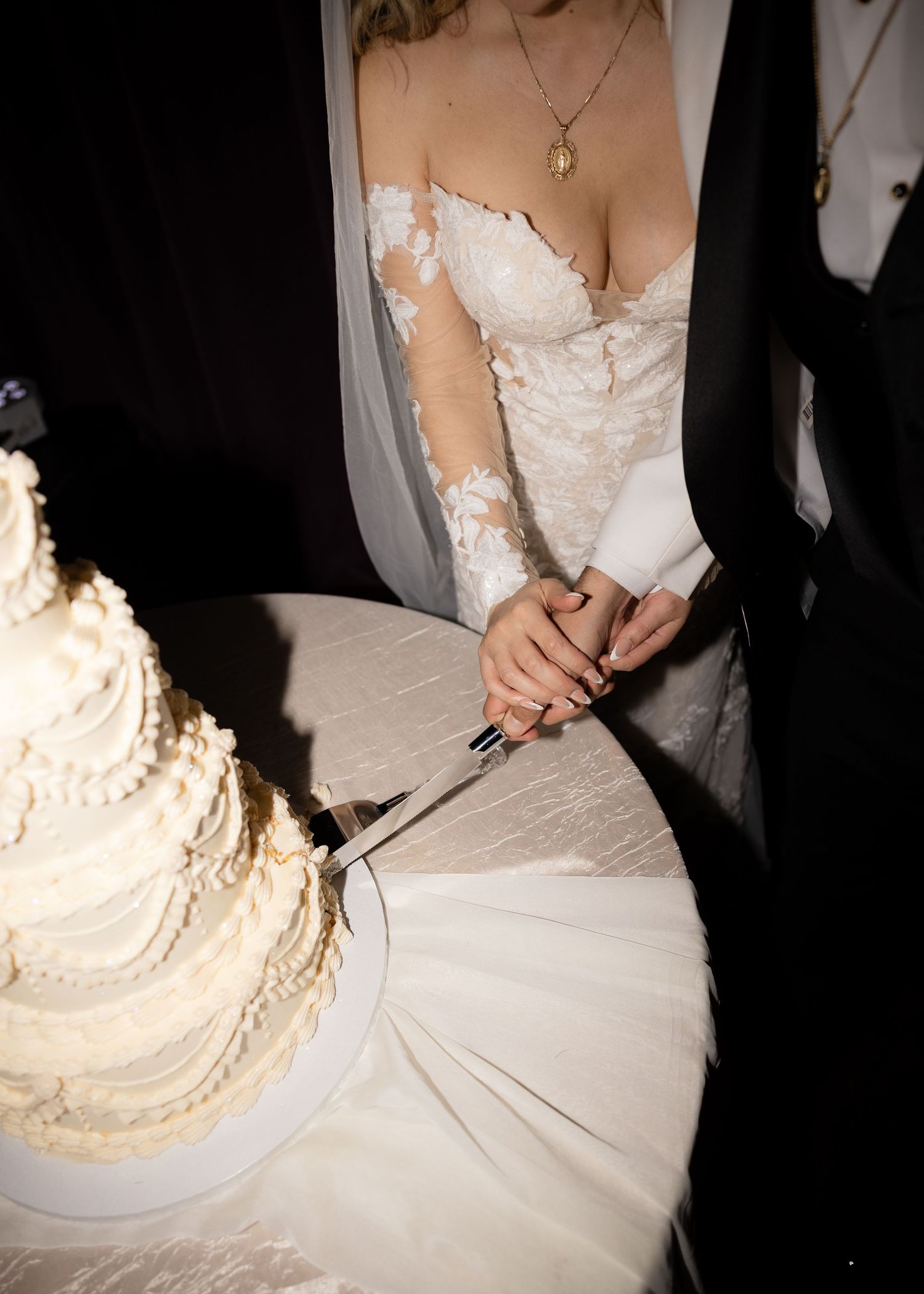 Close-up details of an ornate white wedding dress and lace details.