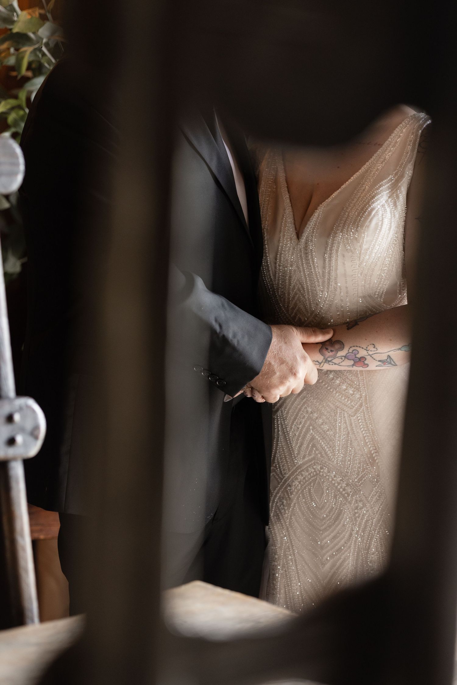 Close-up details of an elegant white wedding dress with intricate beaded patterns and lace textures.