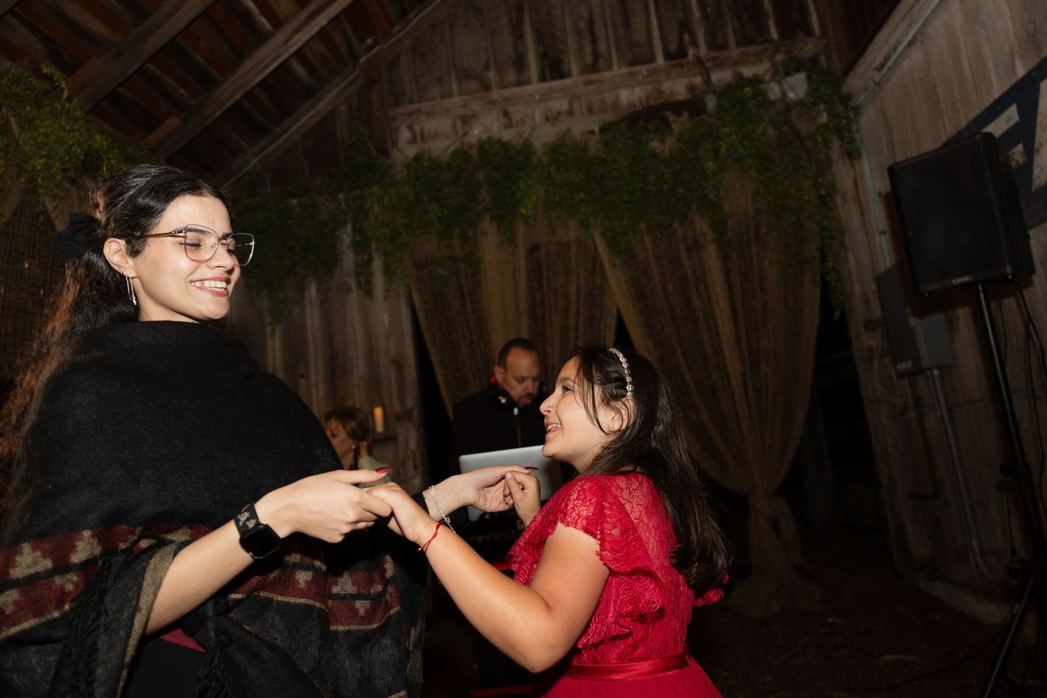 Wedding guests dancing and mingling at a barn reception.