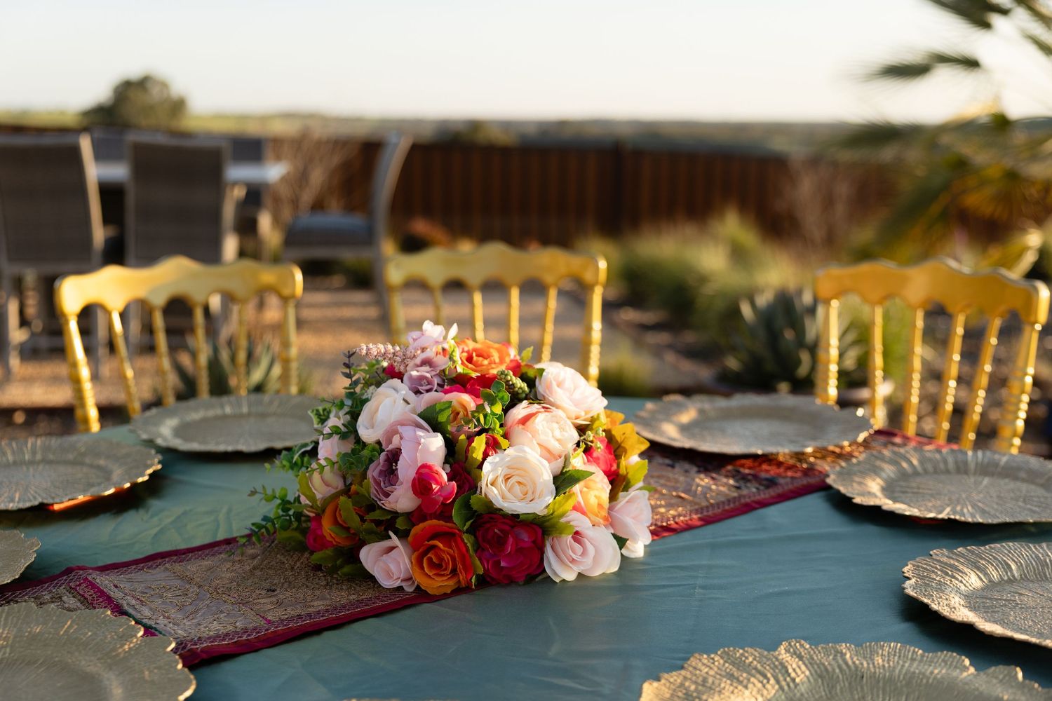 A series of elegant table settings with floral centerpieces and golden chairs at a formal event.