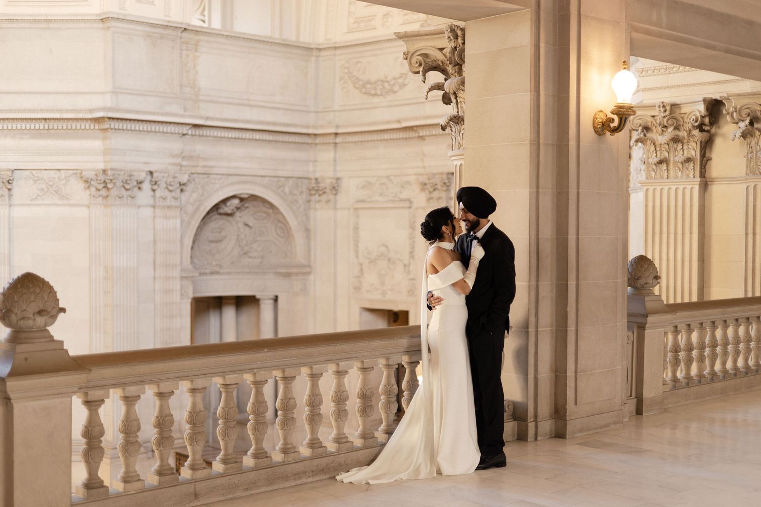 Elegant wedding ceremony photos in a grand marble hallway with ornate white balustrades and classical architecture.