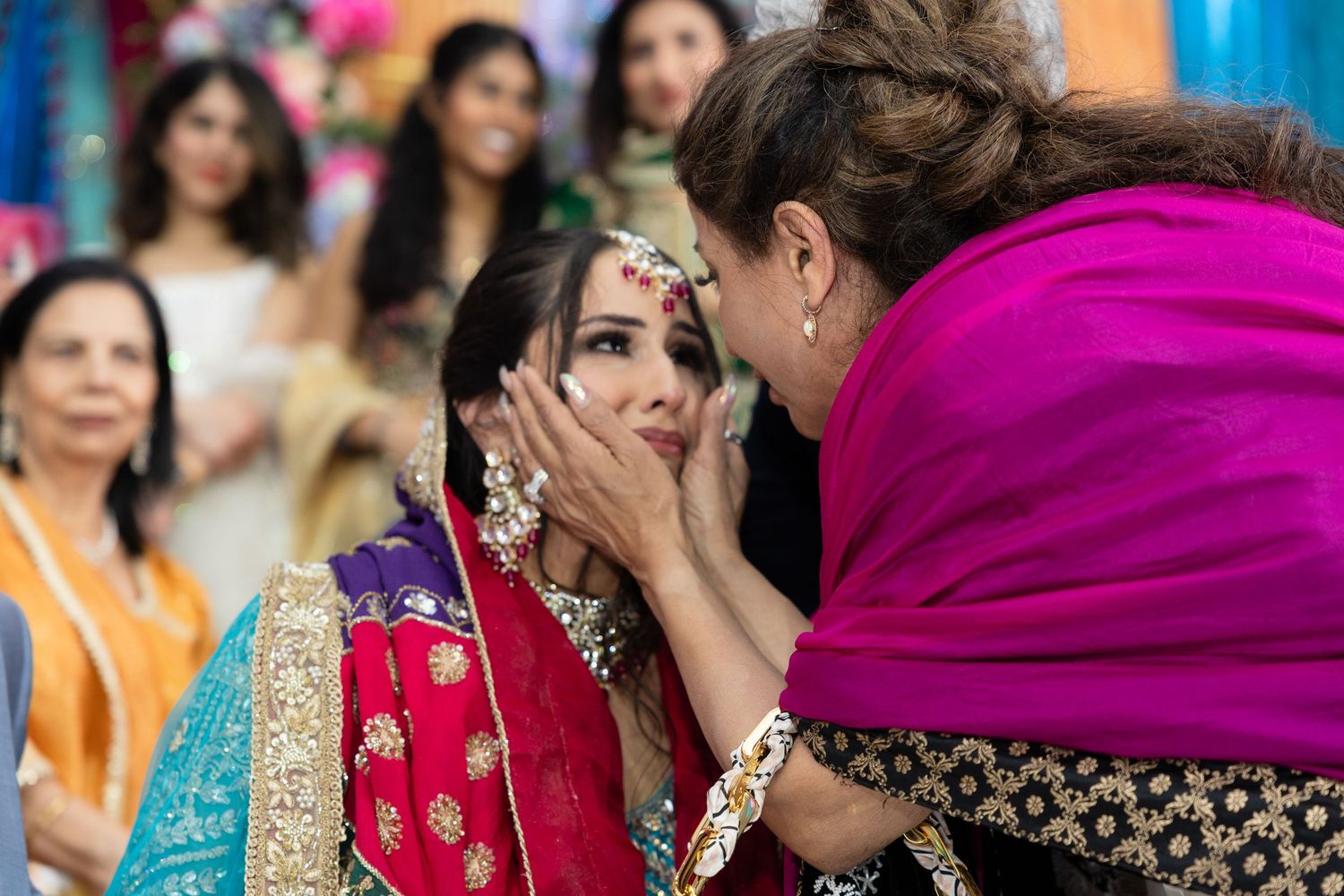 Guests in colorful traditional Indian attire celebrate at a festive gathering with vibrant decorations.
