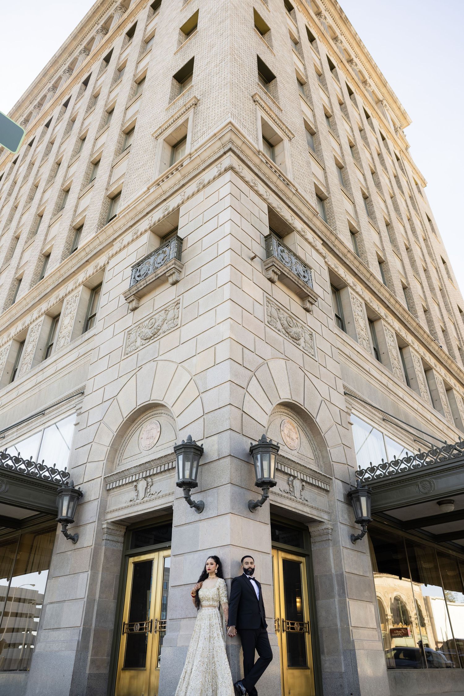 Elegant historic building exterior with stone facade and ornate architectural details featuring arched entryway and lanterns.