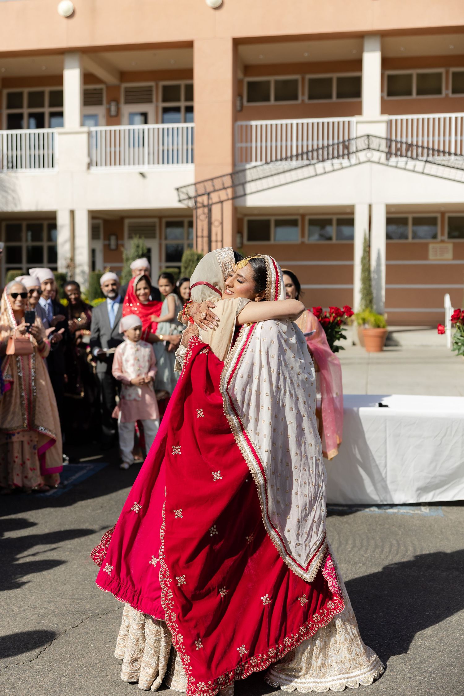 Outdoor wedding celebration at a venue with columns where guests in colorful attire gather for festivities.