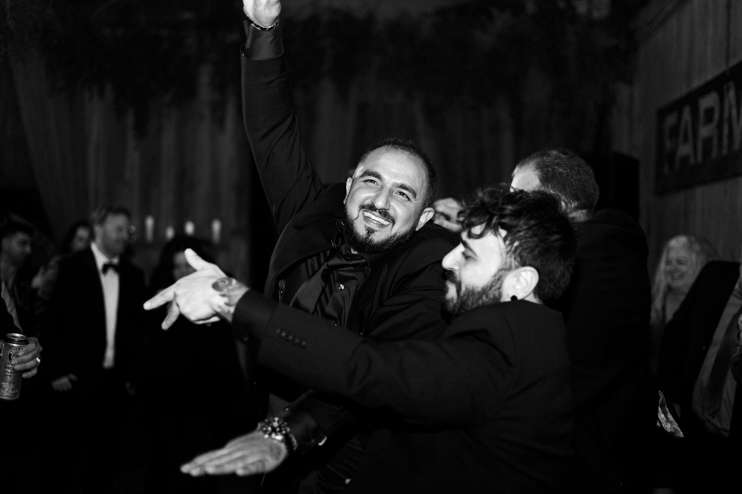 Candid moments of celebration captured at dimly lit wedding reception.