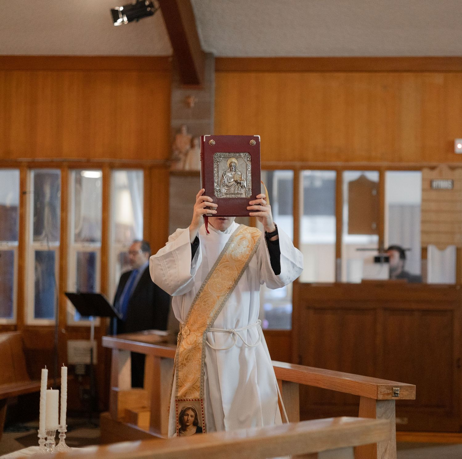 Interior view of a church sanctuary with wooden pews and natural lighting.