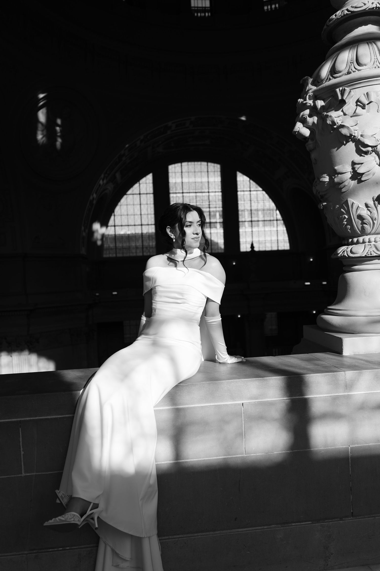 Black and white photo series showing a person in a white dress sitting on stone steps in dramatic lighting and shadows.