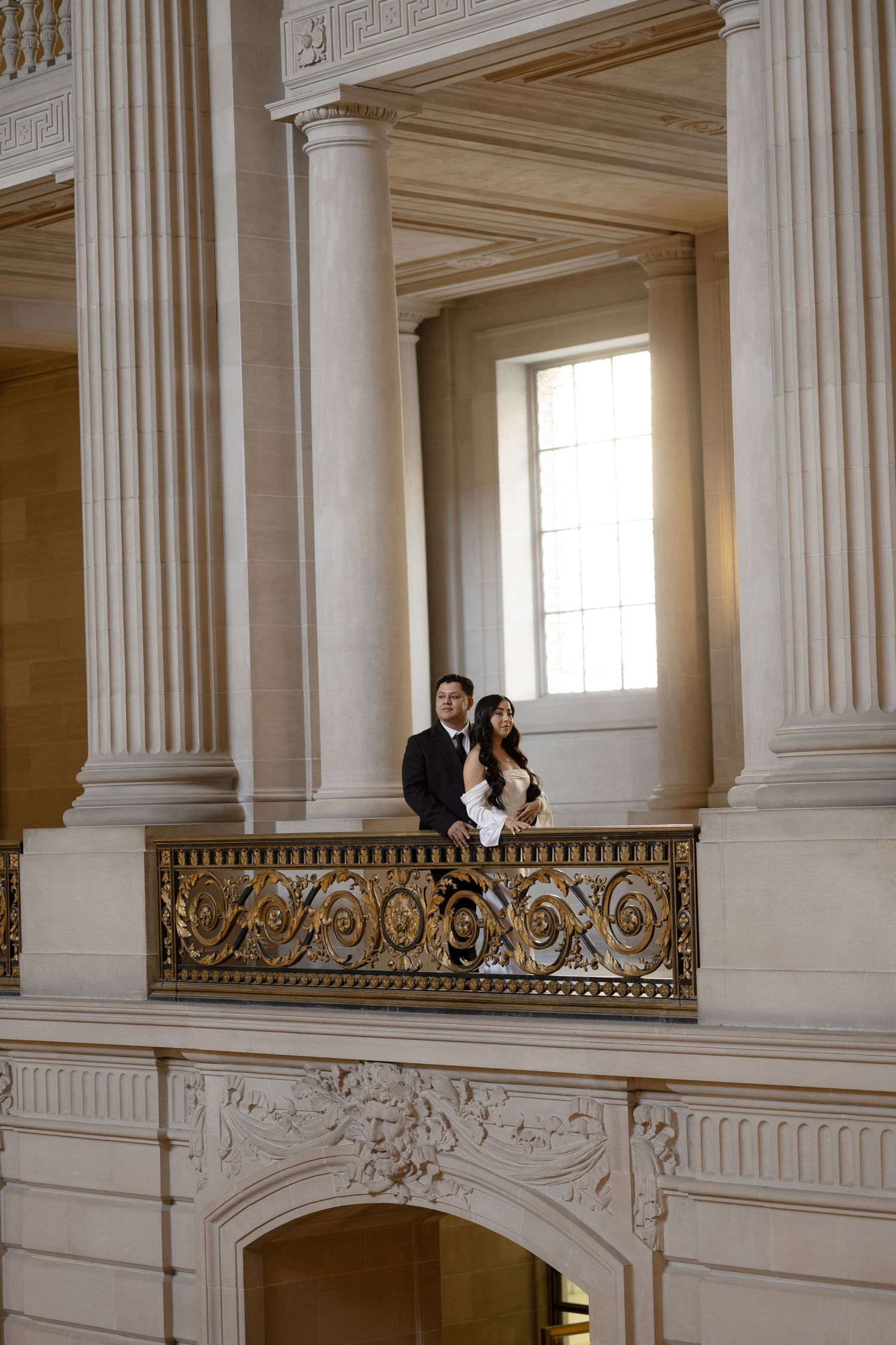 Elegant white marble columns and ornate balcony inside a grand historic building with classical architecture.
