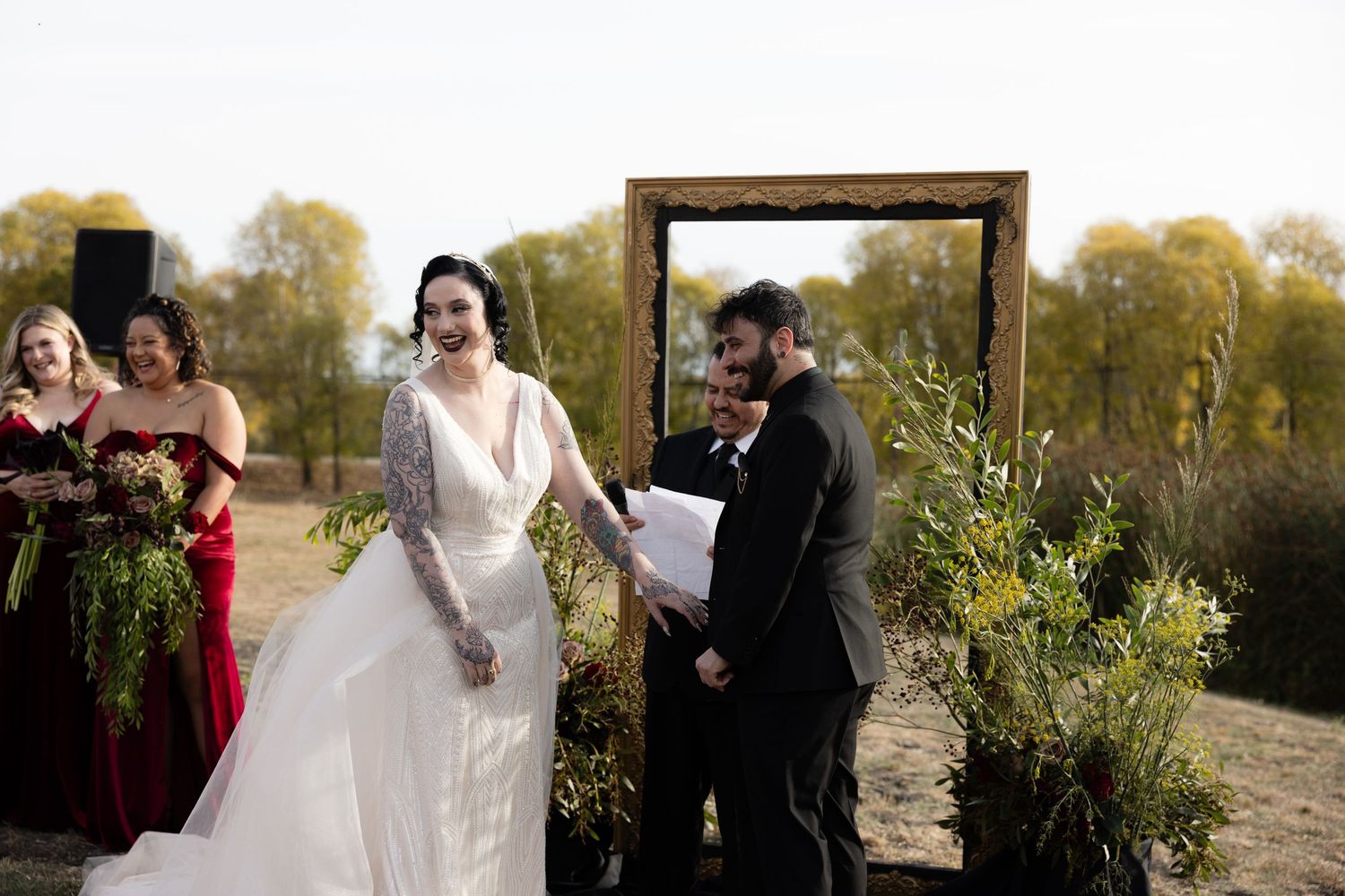 Outdoor wedding ceremony setup with guests gathered in a natural desert landscape setting.