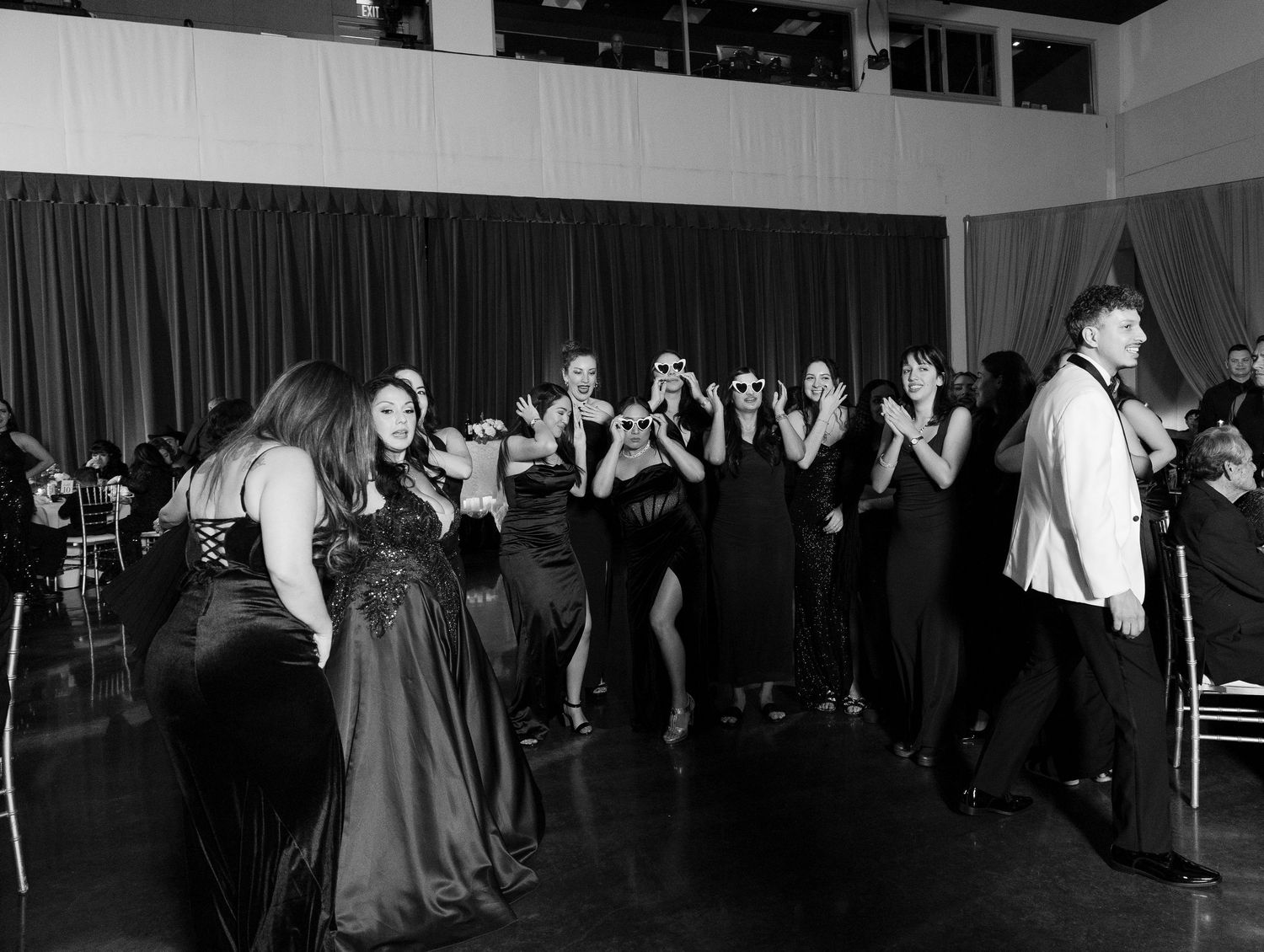 Wide shot of wedding reception dance floor with guests dancing in elegant venue.