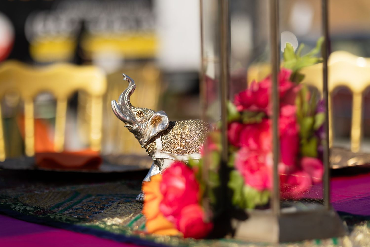 Wedding decor details featuring pink flowers and crystal decorations on a reflective surface.