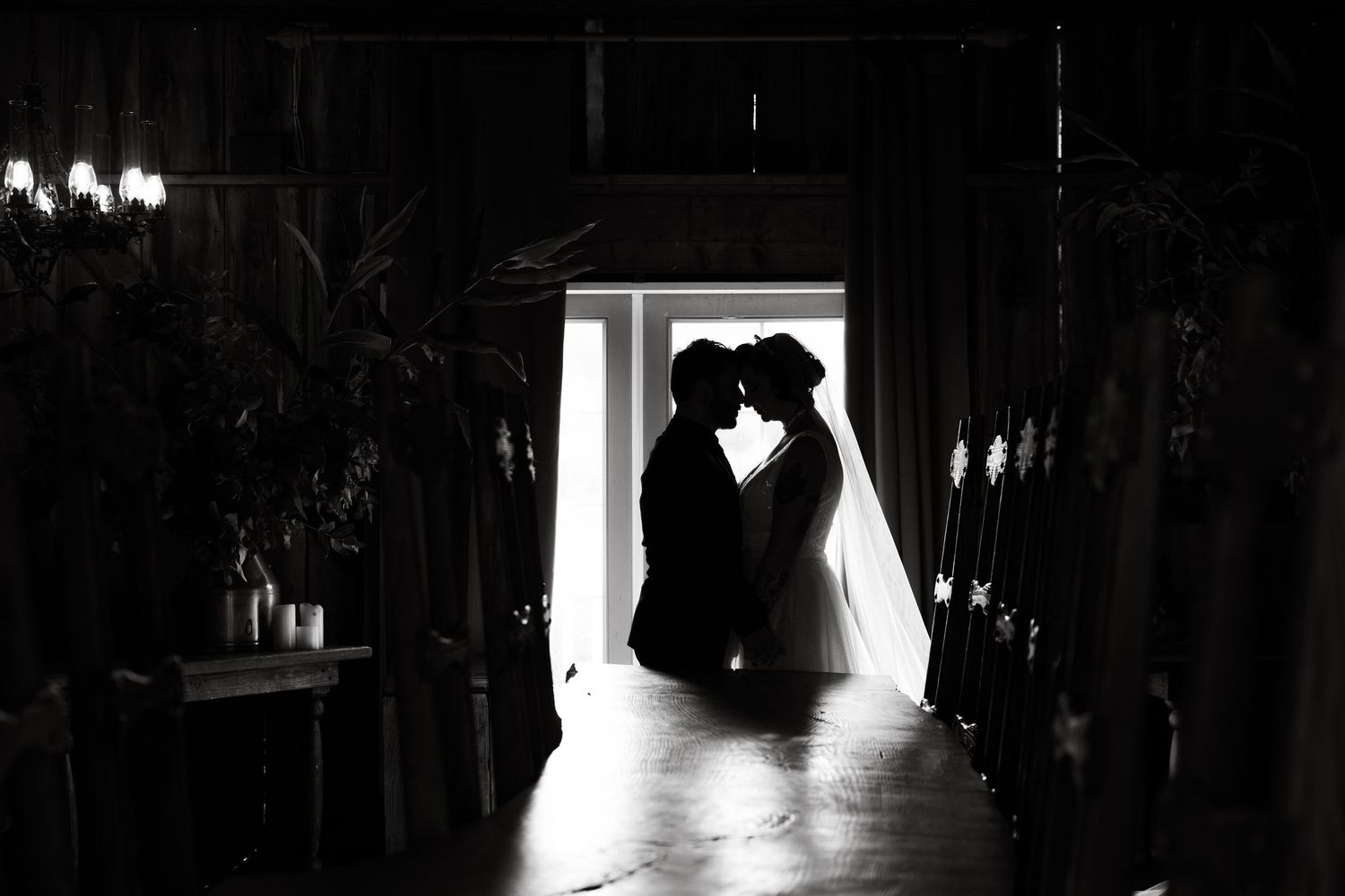 Romantic silhouette of a couple in a doorway with dramatic backlighting.