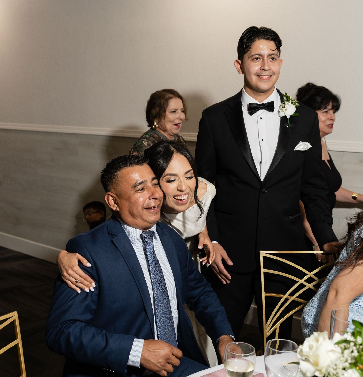 Wedding reception guests laughing and socializing at decorated tables.