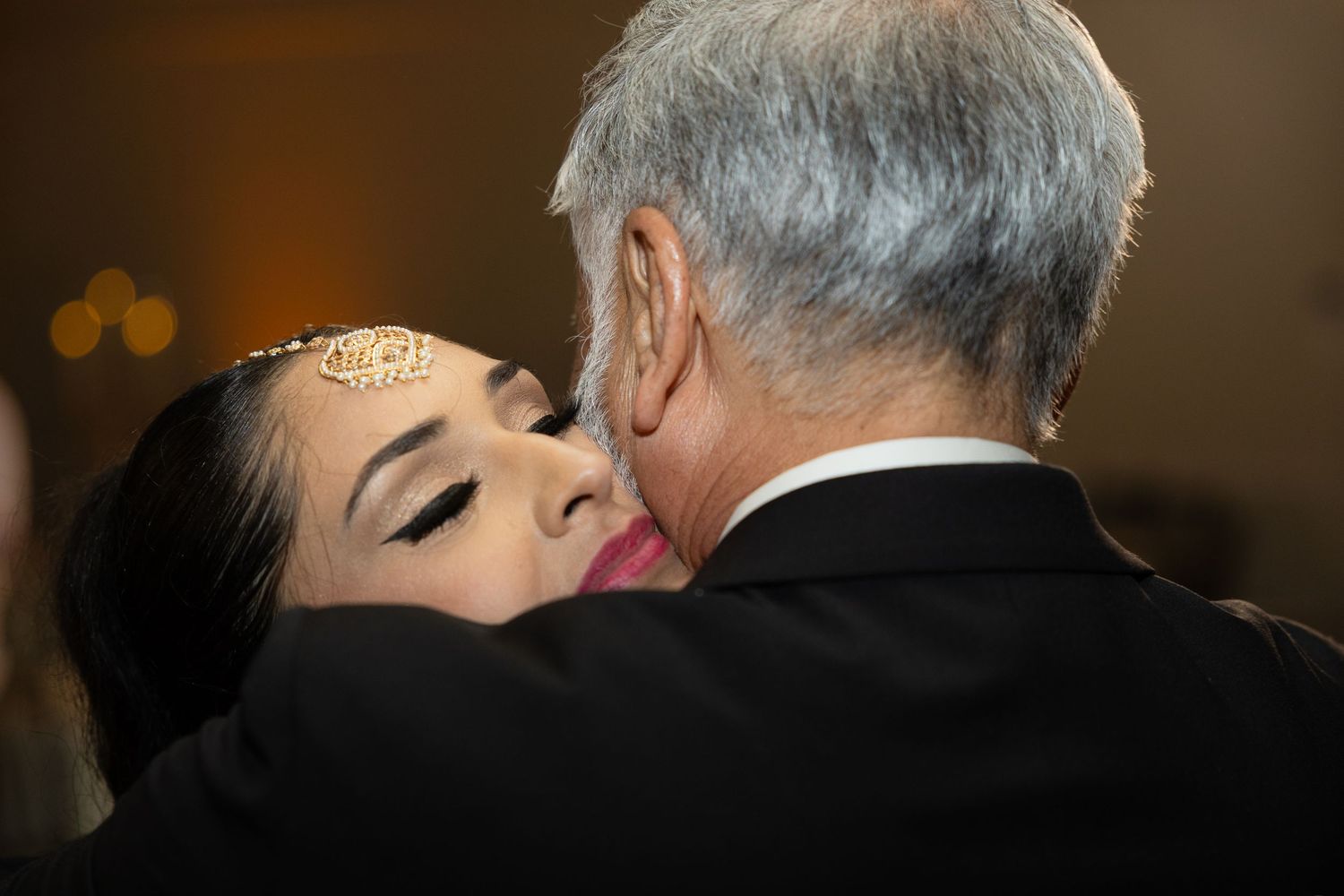 A black and white image showing couples slow dancing at an elegant indoor event.