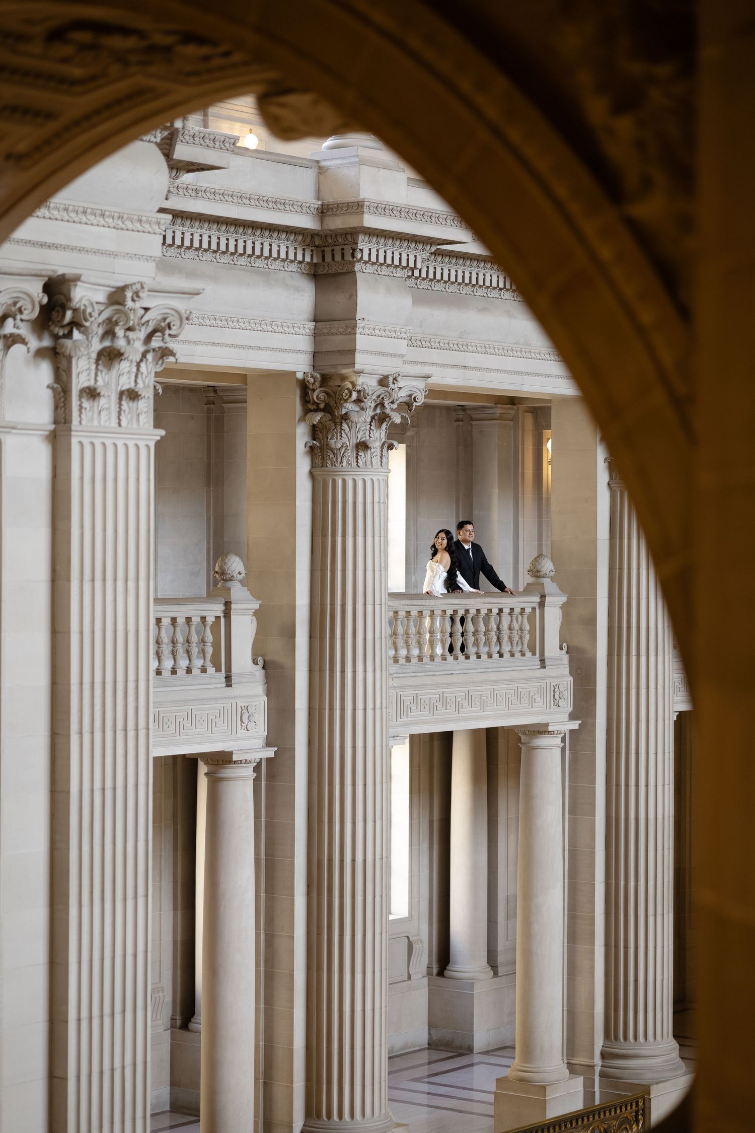 Classical colonnade with white pillars and decorative balustrades creating a symmetrical architectural view.