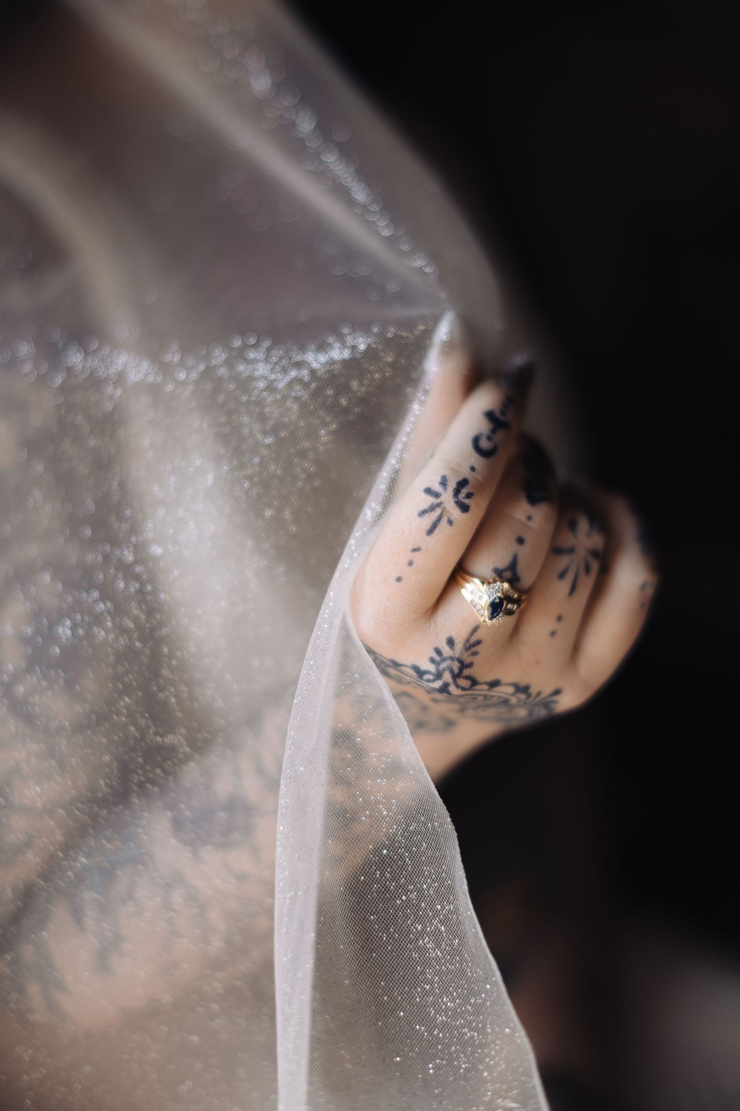 Close-up detail of sparkling tulle fabric and delicate tattoo artwork.