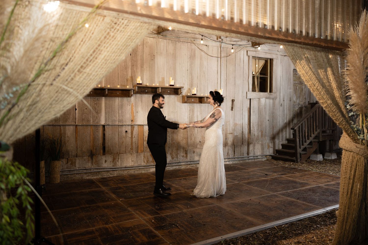 Wedding dance sequence in a rustic barn venue with string lights and wooden walls.