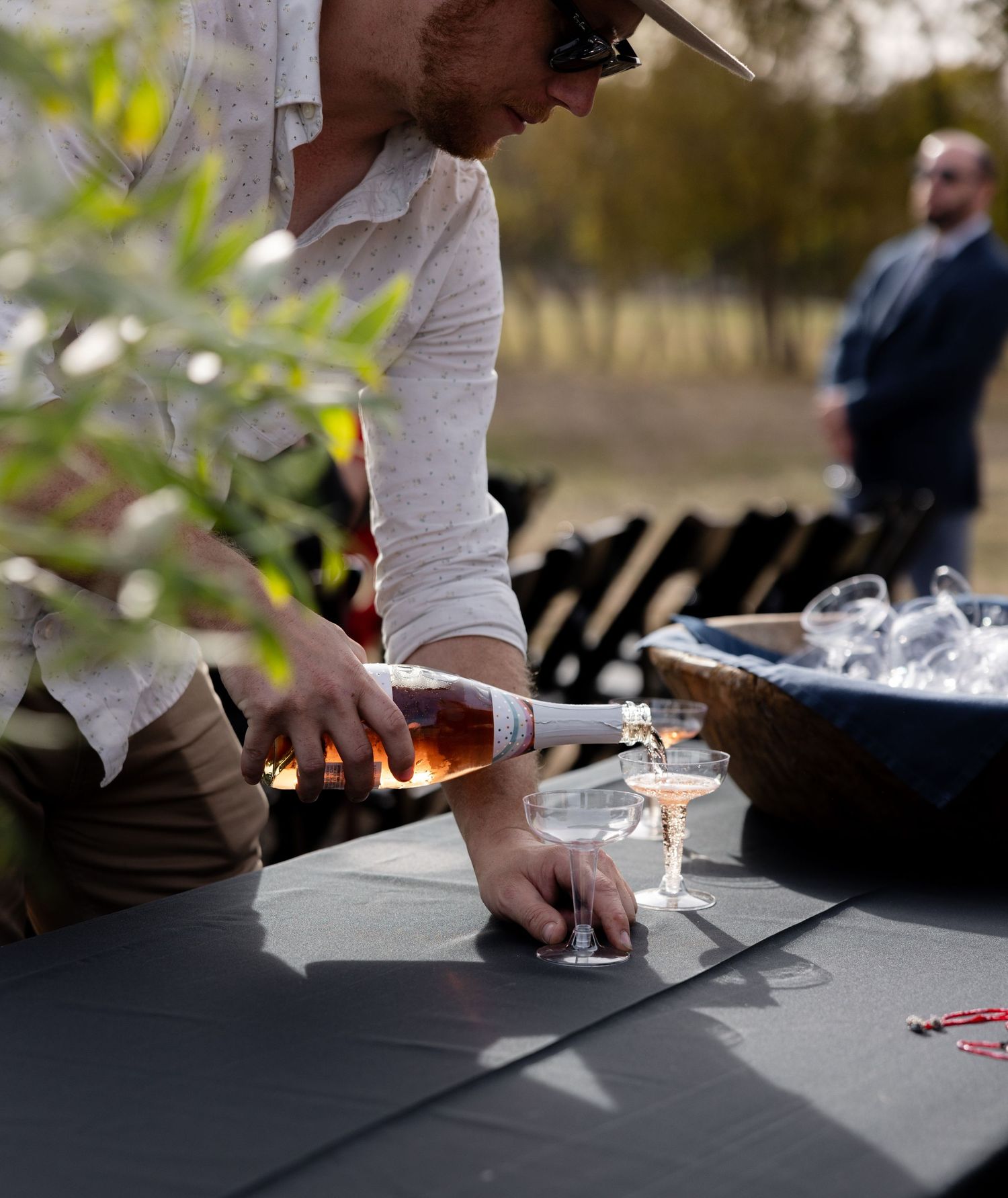Close-up of champagne being poured at an outdoor event with black tablecloth.