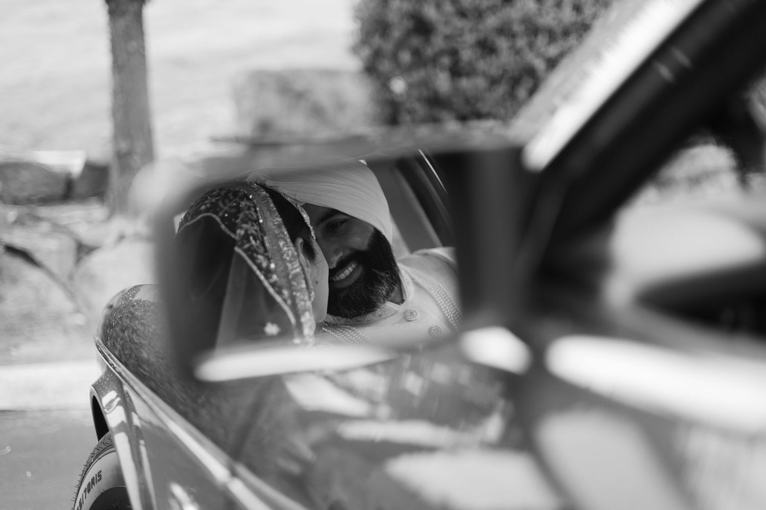 Close-up black and white view of a car side mirror reflection.
