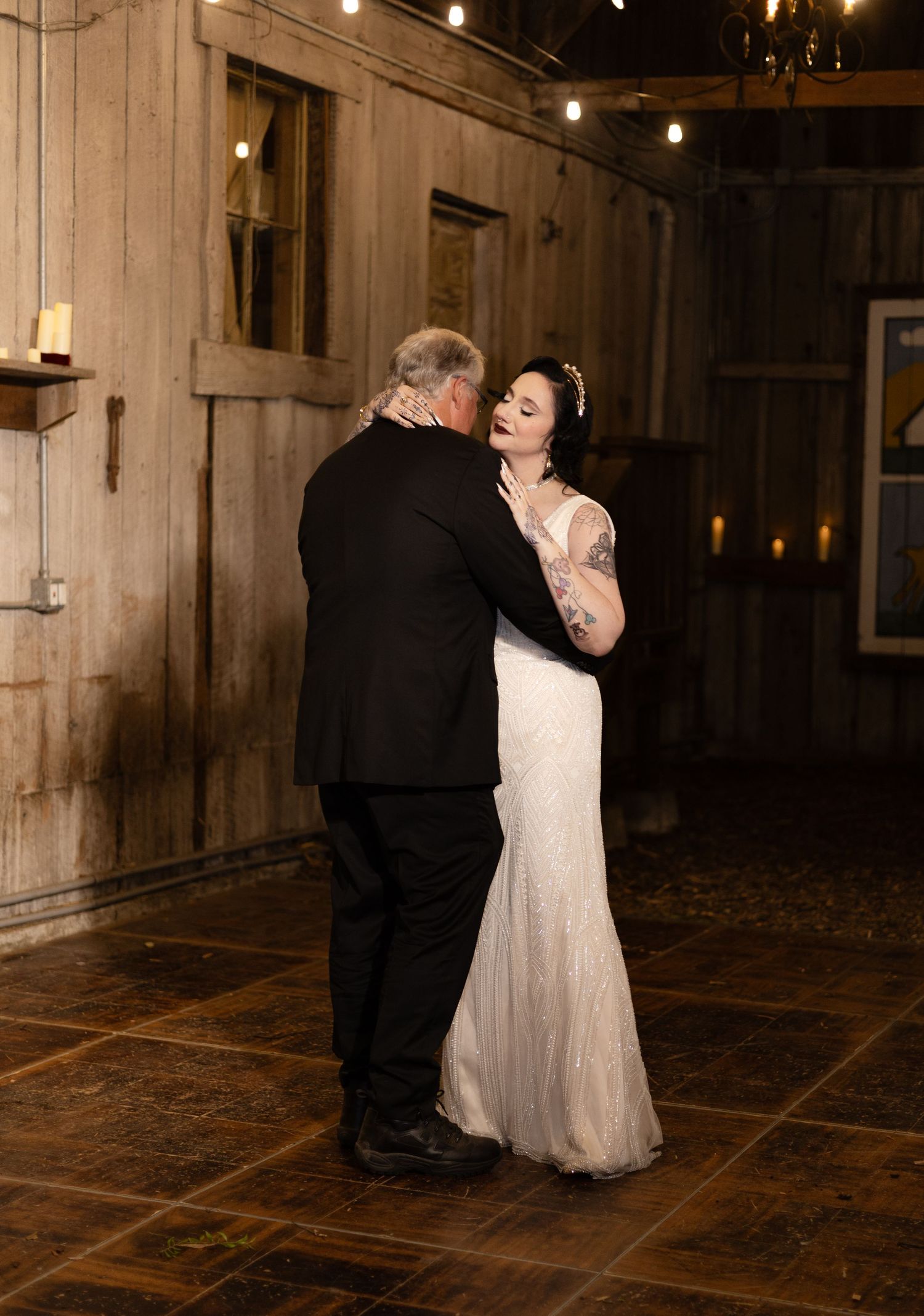 Romantic dance captured in a dimly lit rustic venue with wooden walls and stone flooring.