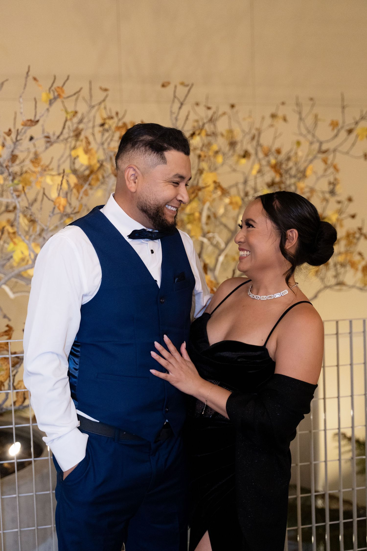 A couple shares a romantic moment during their formal evening celebration.