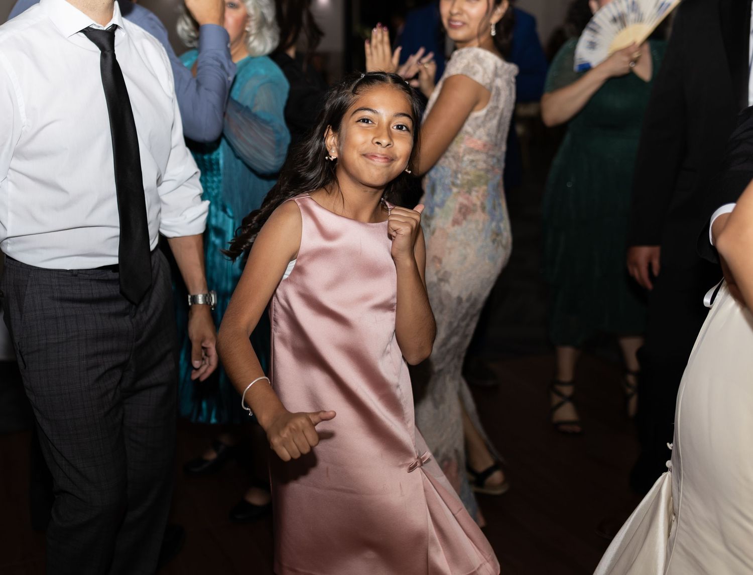 Wedding guests enjoying themselves on the dance floor in formal attire.