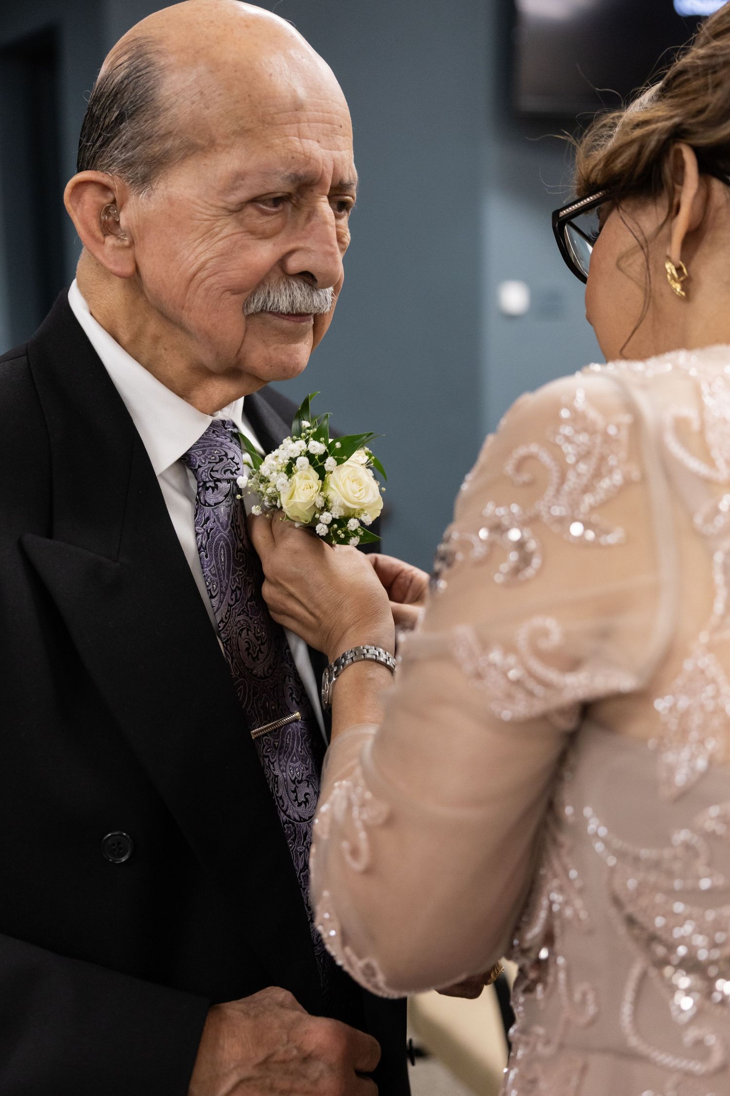 Emotional moment between two people at a formal event with floral boutonniere.