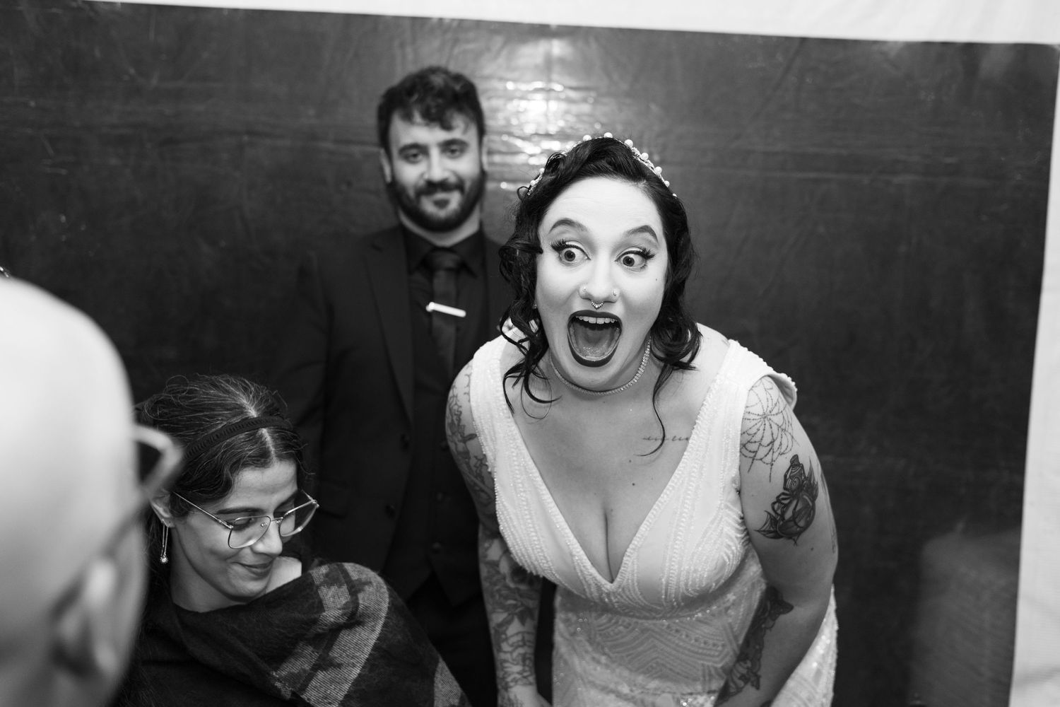 Black and white candid shots of wedding guests showing various emotions at a reception.